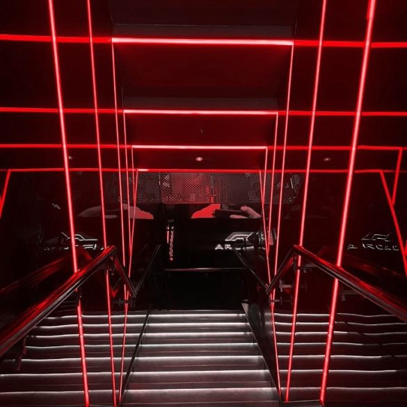 Stairwell wall and ceiling illuminated by red coloured LED linear strip lighting