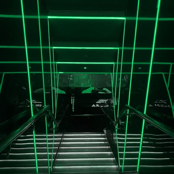 Stairwell wall and ceiling illuminated by green coloured LED linear strip lighting